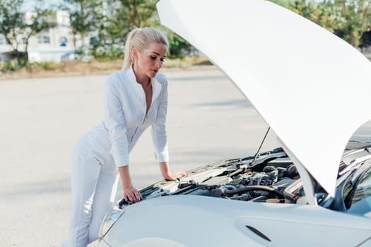 Female car mechanic repairing car engine in garage