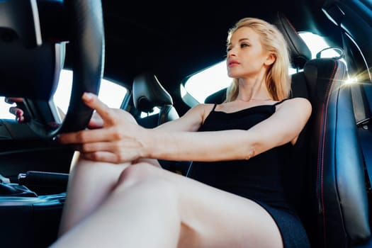 Woman in black summer dress car driver driving on road