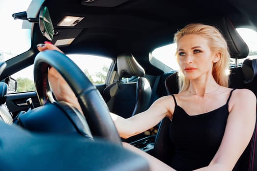 Woman in black summer dress car driver driving on road