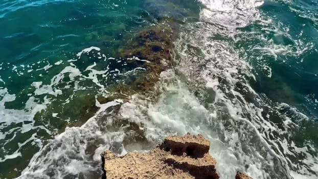 Dynamic ocean waves powerfully splash against rugged rocks, beautifully capturing the breathtaking natural beauty