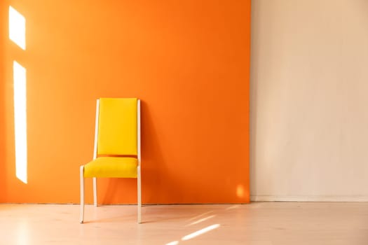 One yellow vintage chair in the interior of a fluffy room with an orange wall