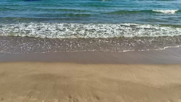 Catch the incredible beauty of gentle waves lapping at a sunlit beach, evoking feelings of peace and relaxation