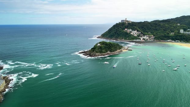 A stunning aerial shot capturing a tranquil coastal area where boats float in clear waters, surrounded by lush greenery