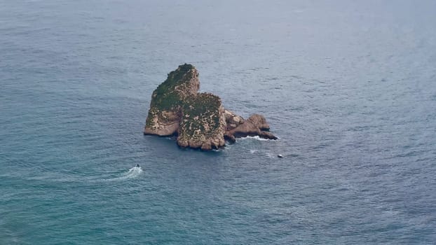 An aerial shot captures the stunning beauty of a picturesque island, surrounded by tranquil ocean waves