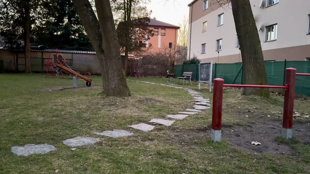 A calming and serene playground scene shows a lovely pathway, tall trees, and a cozy, enchanting sunset ambiance