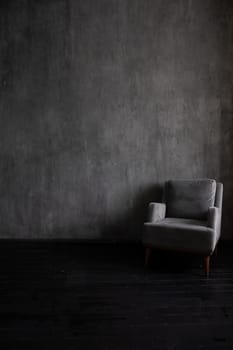 Old vintage armchair in the interior of a dark gray room