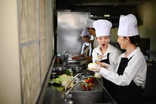 Cooking class participants preparing produce together in culinary school.