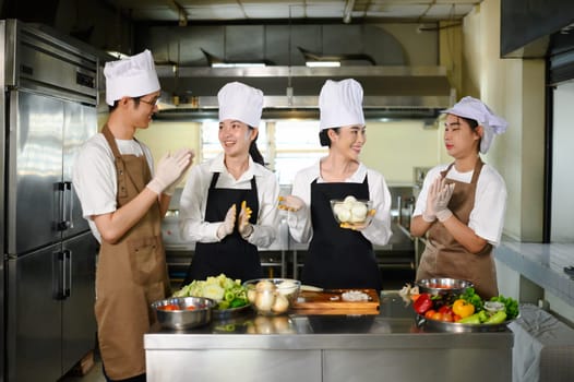 Group of culinary students discussing recipe and preparing vegetables during a cooking class.