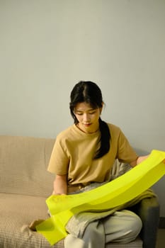 Female doing resistance band workout in a bright living room. Home fitness concept.