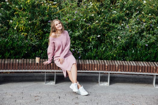 blonde woman in knitted pink dress drinking coffee cocktail