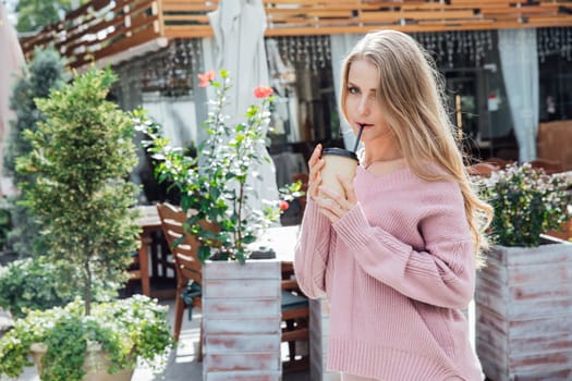 blonde woman in knitted pink dress drinking coffee cocktail