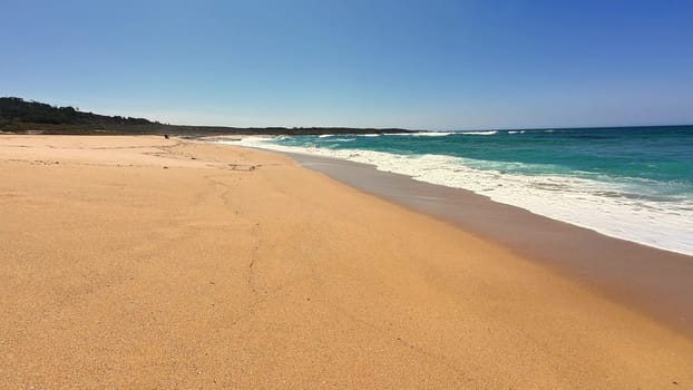 A serene and tranquil beach scene showcasing soft golden sand and gentle waves, ideal for complete relaxation