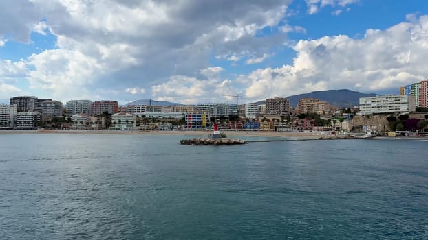 A stunning view of a coastal city by the sea under a cloudy sky, perfect for showcasing waterfront beauty.