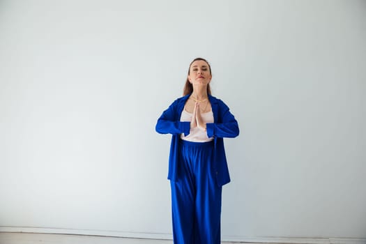Brunette woman in blue business suit praying
