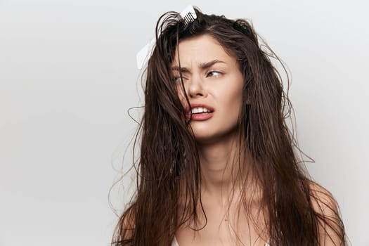 Hair, beauty, woman with messy hair and an expressive facial expression The model s hair is disheveled and slightly damp, set against a plain white background that enhances her natural beauty