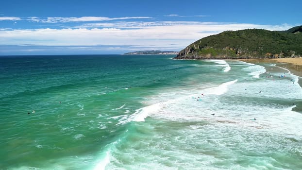 A beautiful panorama of the ocean featuring gentle waves and vibrant turquoise colors under a clear blue sky.