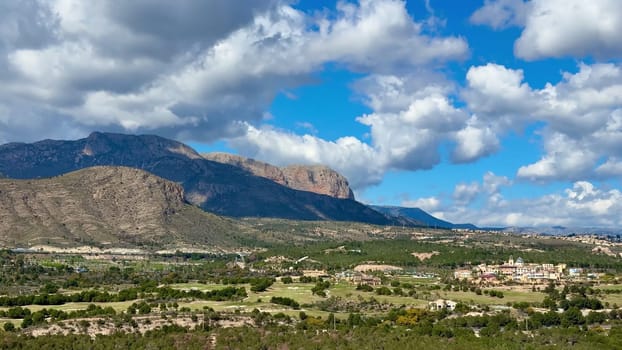 A stunningly beautiful view showcasing majestic mountains and a vibrant, lush landscape beneath a dramatic sky