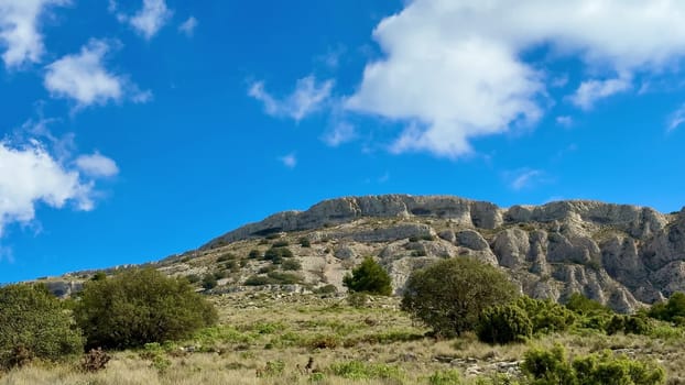 The breathtaking and mesmerizing view of rugged mountains accompanied by lush green vegetation beneath a clear blue sky