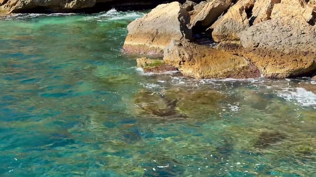 A stunning coastal landscape of rugged shoreline meeting clear turquoise waters, offering a breathtaking view