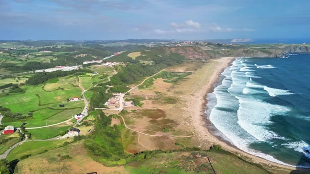 A breathtaking aerial shot captures a vibrant and colorful coastal landscape combined with rich, lush greenery