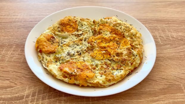 A fluffy, delicious omelette that is beautifully garnished with fresh herbs, perfect for breakfast or brunch meals