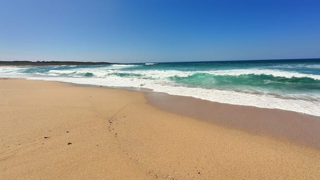 A peaceful and tranquil beach scene showcasing soft, gentle waves lapping against a bright, sunny shore
