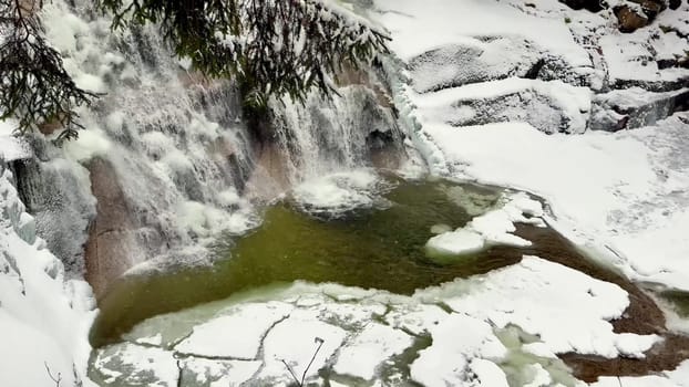 Imagine a picturesque winter scene featuring a beautiful cascading waterfall surrounded by glistening snow and ice