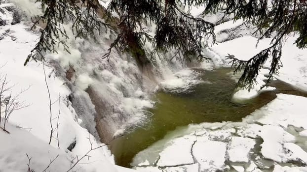 Snowy and frozen forest waterfall. View from above. High quality 4k footage