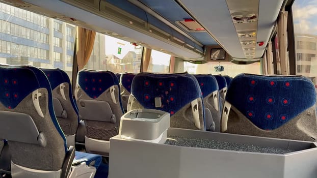 A spacious and inviting view of a contemporary bus interior featuring plush, comfortable seats and large windows
