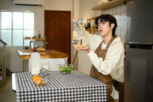 Smiling man enjoying breakfast with cereal and milk in a bright kitchen.