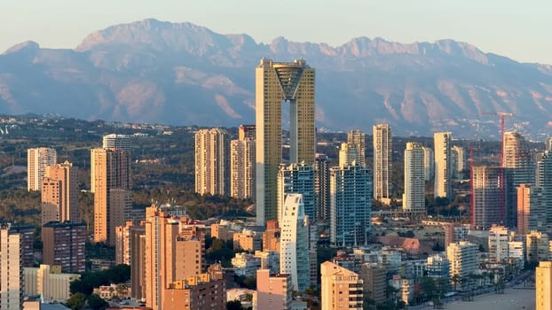 A breathtaking and stunning skyline that beautifully captures urban architecture along with scenic mountains at sunset