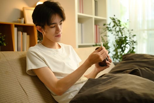 Depressed male struggling with mental health, holding a pill bottle in emotional distress.