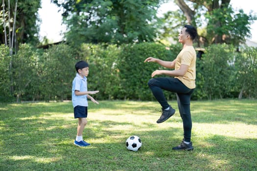 A father and his son engaged in soccer practice, fostering teamwork and fitness in a lush, green garden environment.