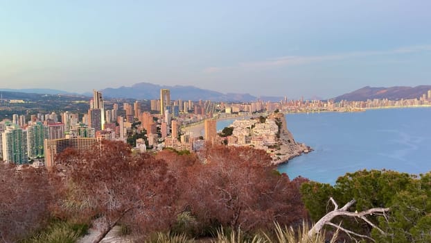 This scenic waterfront view showcases charming buildings and serene landscapes under soft, warm light