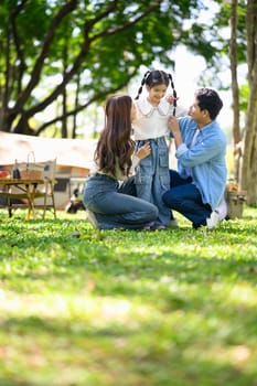 Family having fun at a campsite with tents in the background.