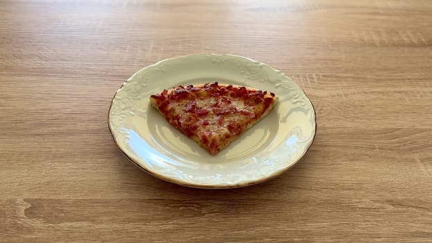 A delicious and tempting slice of pizza is beautifully resting on a decorative plate, ideal for food lovers everywhere