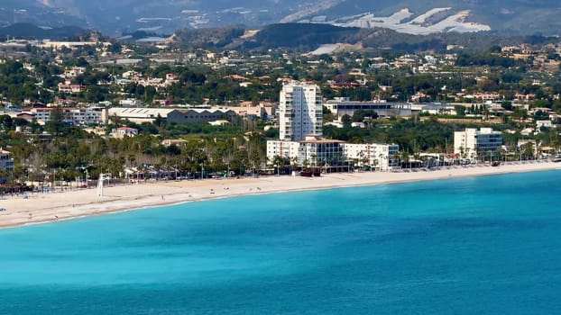 Aerial view shows a vibrant coastal area with golden beaches and stunning turquoise waters stretching far