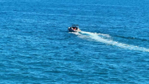 A speedboat races across stunning blue waters under a clear sky, perfect for unforgettable summer adventures