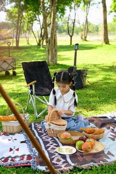 Cheerful asian girl enjoying outdoor adventure at a campsite.
