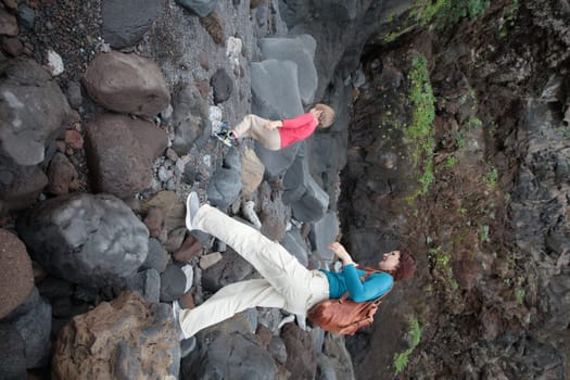 Tourists exploring volcanic cave walking on rocks