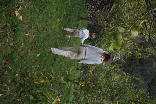 Mother and son enjoying a stroll through a lush orchard, holding hands and creating a heartwarming moment of family bonding