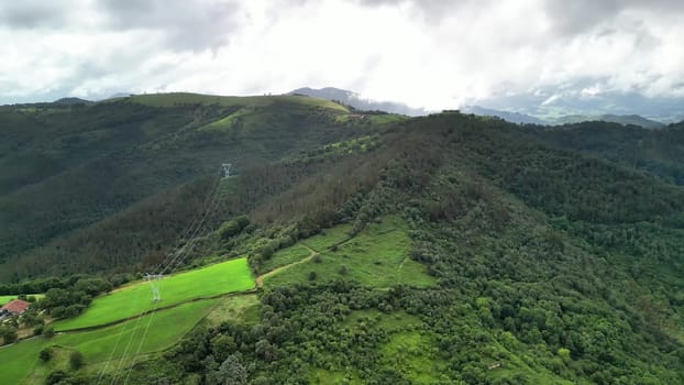 A breathtakingly majestic aerial landscape showcasing vibrant green fields and rolling hills beneath a cloudy sky