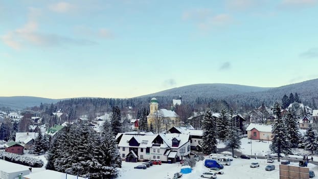 A picturesque winter scene of a charming quaint village entirely blanketed in fresh snow beneath clear blue skies