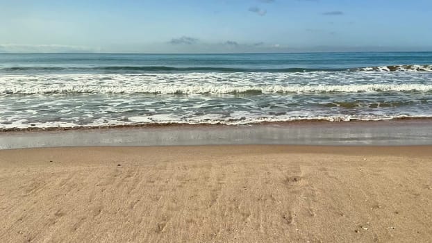 Gentle sea relaxing waves on a sandy beach. High quality 4k footage