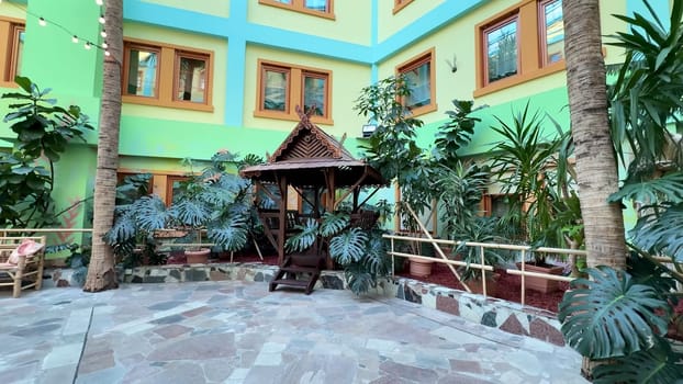 A vibrant and lively courtyard adorned with exotic plants and a delightful gazebo, ideal for relaxation and enjoyment