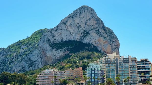 A breathtaking and stunning view of a coastal mountain standing majestically next to modern residential architecture