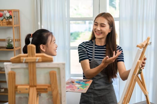 A vibrant scene of a mother and daughter enjoying painting together, fostering creativity and love in their family time.