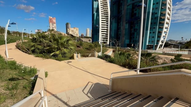 Experience a stunning view of a modern park with innovative curved buildings and vibrant greenery for guests
