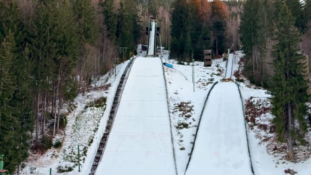 A picturesque winter landscape showcasing impressive ski jumping ramps that are nestled among the trees