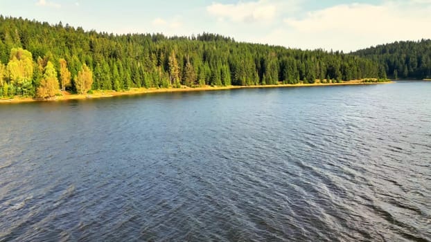 A picturesque lake setting adorned with vibrant foliage beautifully reflecting on the surface of the water